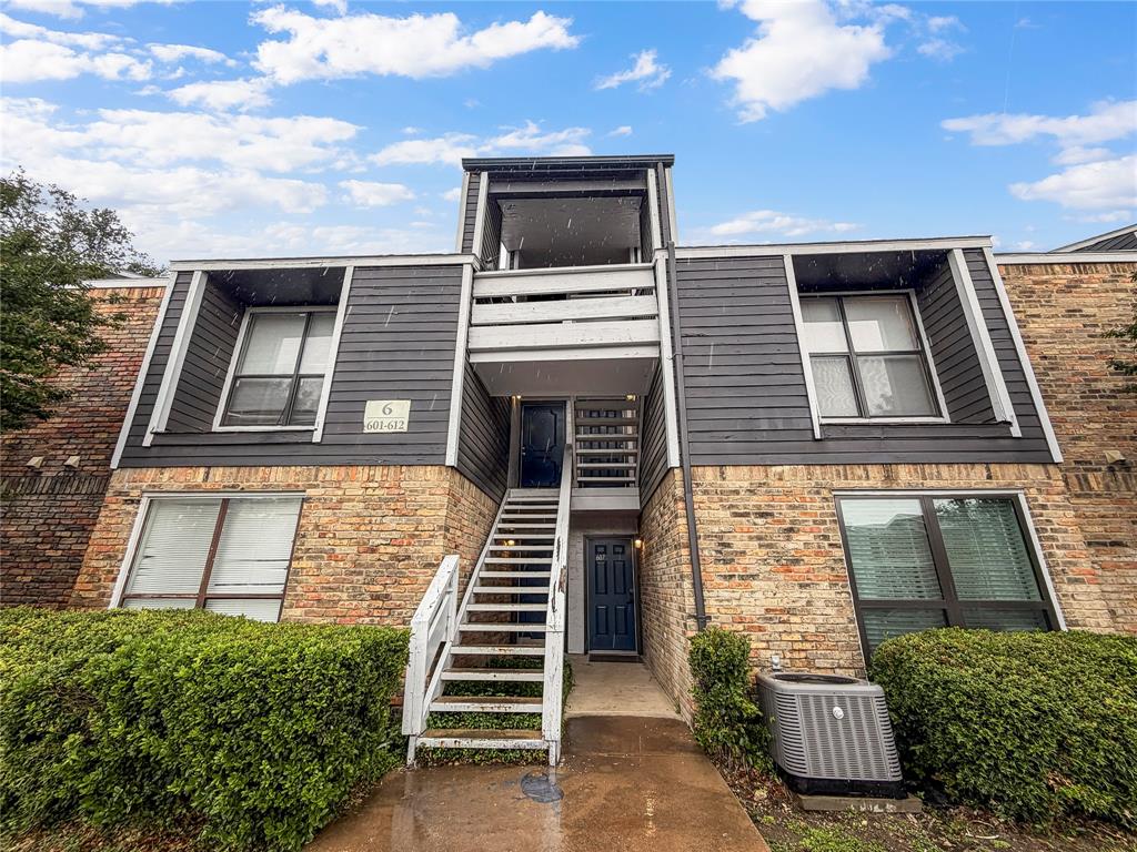 Multi-level exterior featuring dark horizontal siding and brick accents