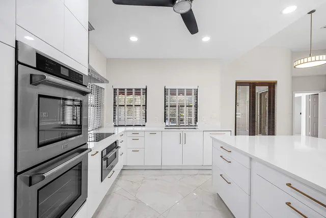 a kitchen with white cabinets and appliances