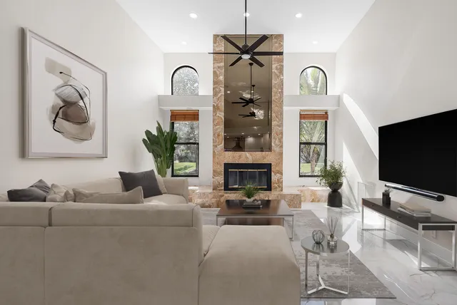 a living room with furniture a flat screen tv and a large window
