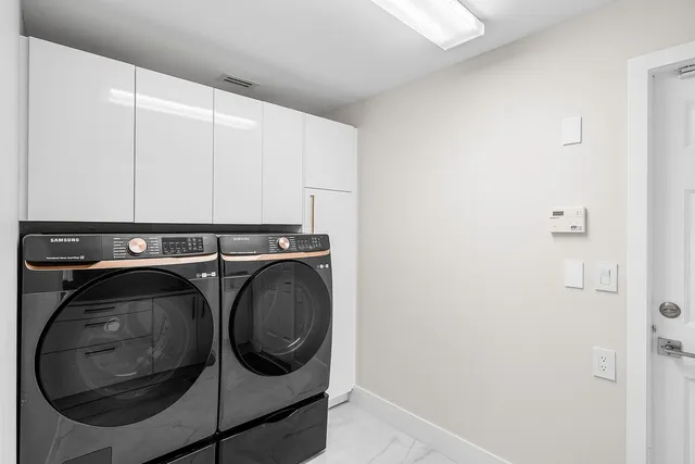 a front view of a house with a yard and potted plants