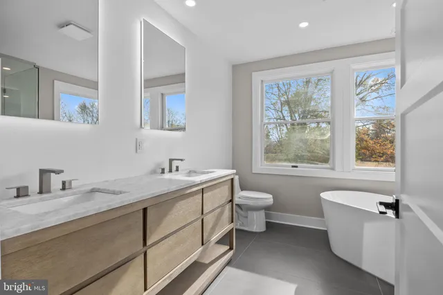 a bathroom with a granite countertop sink mirror vanity and toilet