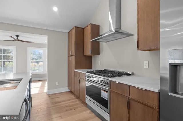 a kitchen with kitchen island stainless steel appliances a sink stove refrigerator and cabinets