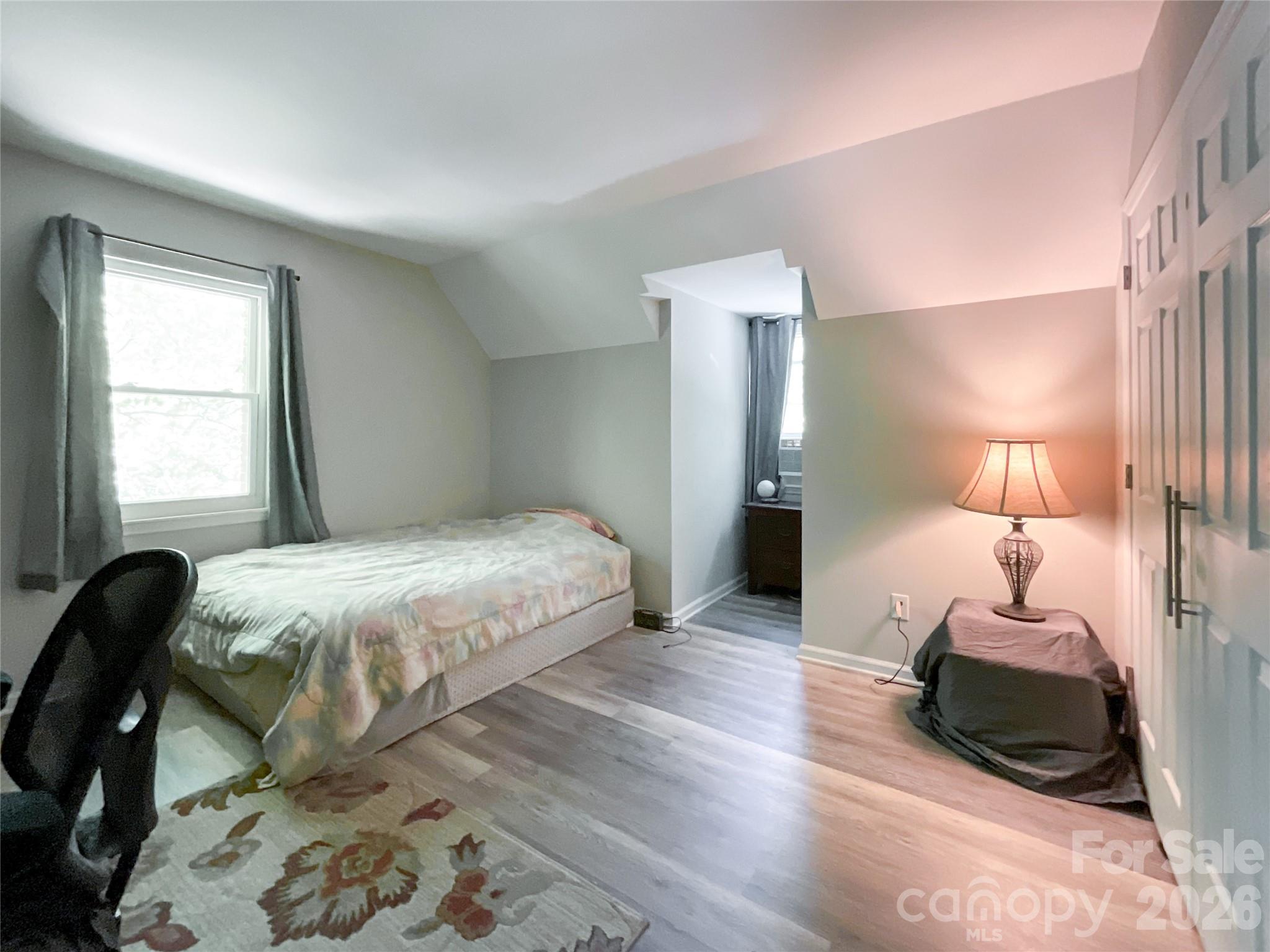 2113 Killarney Place Charlotte, NC 28262 - Photo 15 of 19 a spacious bedroom with a bed a lamp and a large window
