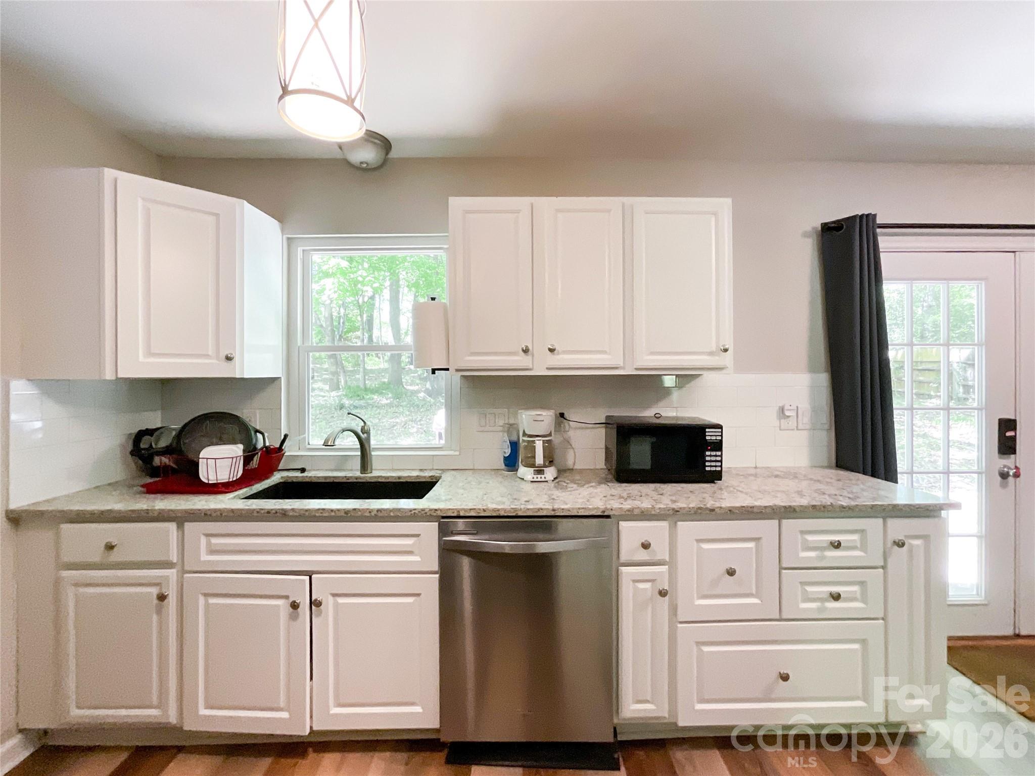 2113 Killarney Place Charlotte, NC 28262 - Photo 8 of 19 a kitchen with white cabinets and appliances