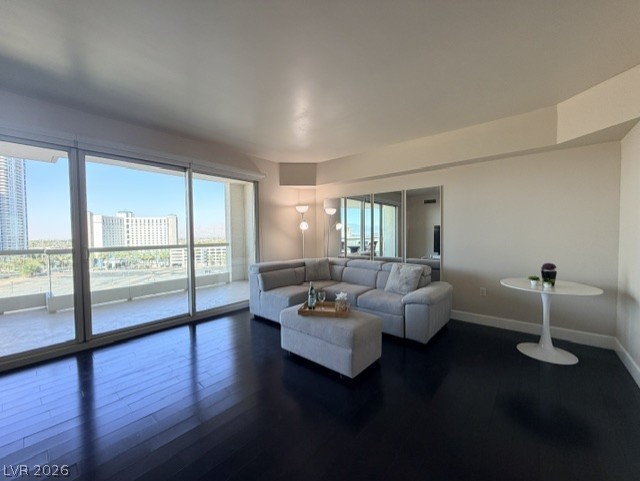 2777 Paradise Road, Unit 807 Las Vegas, NV 89109 - Photo 45 of 61 Floor-to-ceiling windows flood this living space with natural light, complementing the dark hardwood flooring.