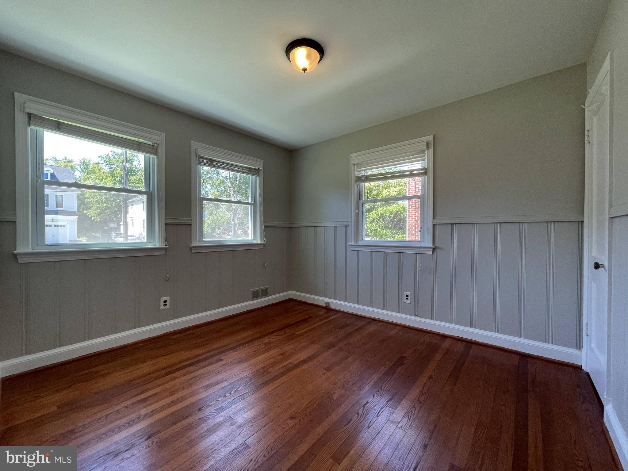 5817 Kingswood Road Bethesda, MD 20814 - Photo 19 of 40 an empty room with wooden floor and windows