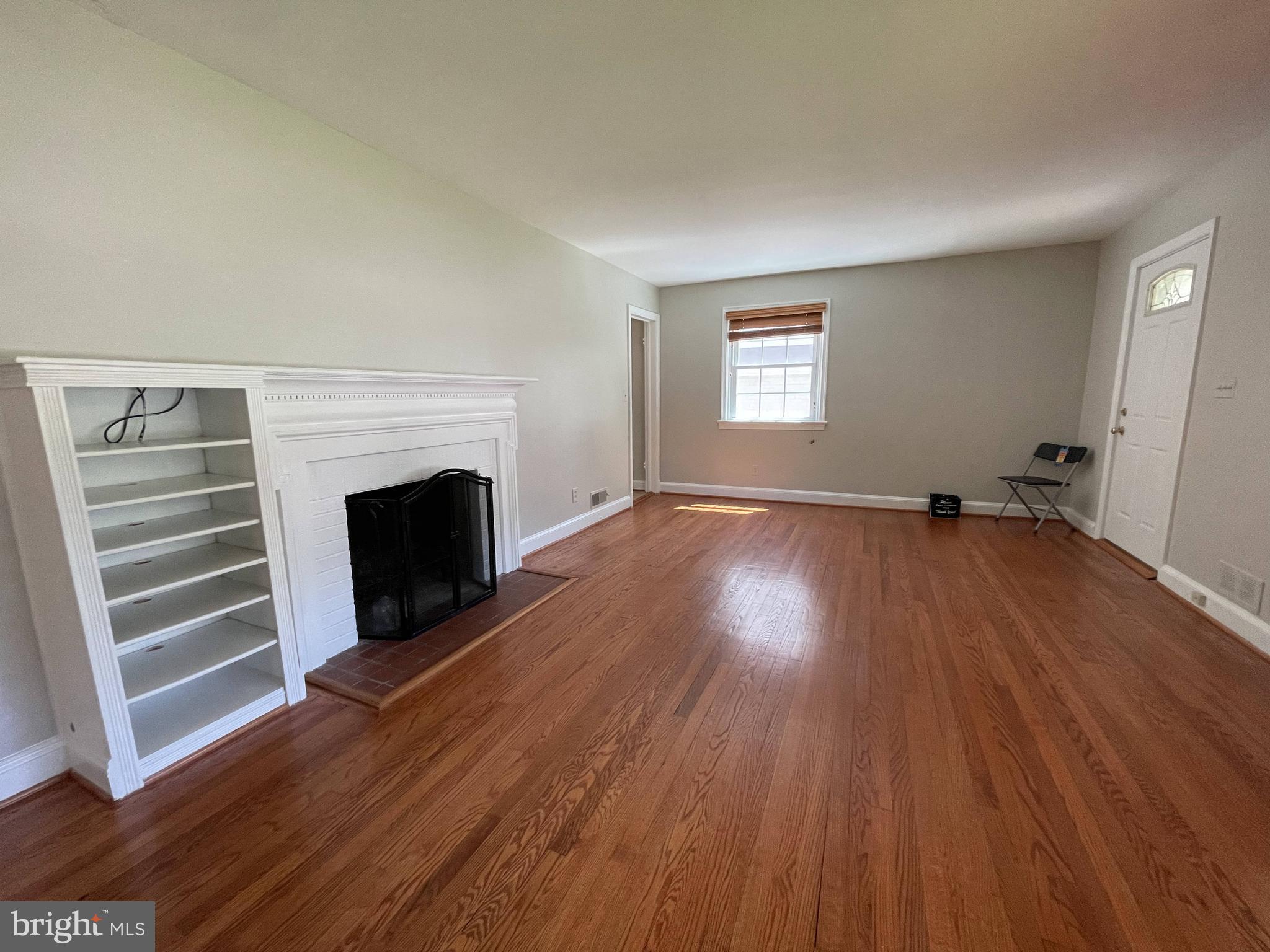 5817 Kingswood Road Bethesda, MD 20814 - Photo 7 of 40 a view of an empty room with wooden floor fireplace and a window