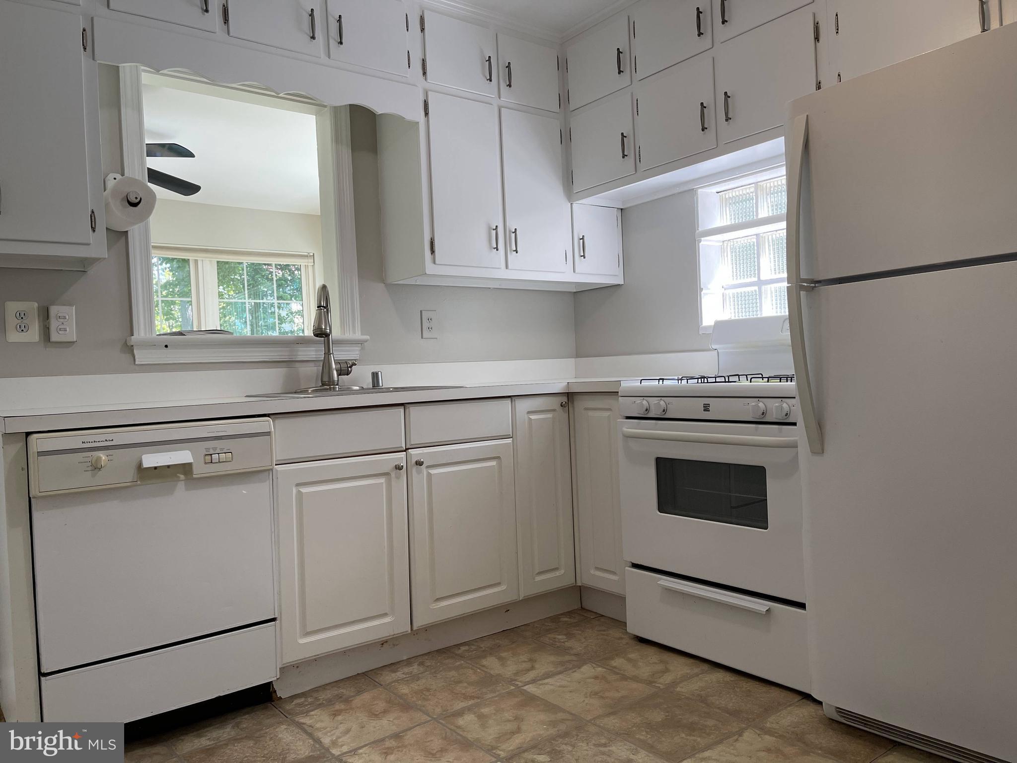 5817 Kingswood Road Bethesda, MD 20814 - Photo 10 of 40 a kitchen with white cabinets stainless steel appliances and sink
