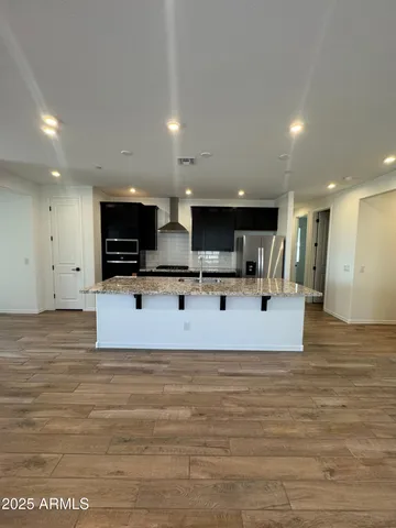 a large white kitchen with kitchen island a sink stainless steel appliances and cabinets