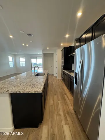 a kitchen with kitchen island a counter top space cabinets and stainless steel appliances