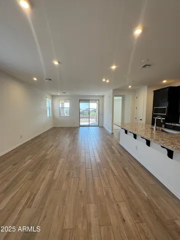 a view of a big room with wooden floor and windows