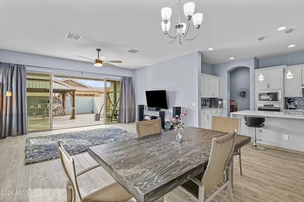 a view of a dining room with furniture a chandelier and wooden floor