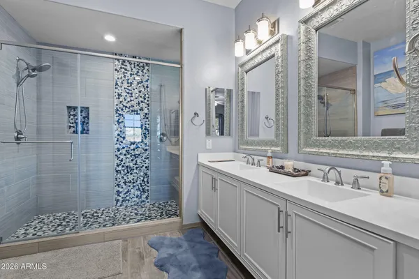 a bathroom with a double vanity sink mirror and shower