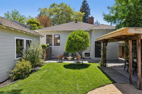a view of a house with backyard and sitting area