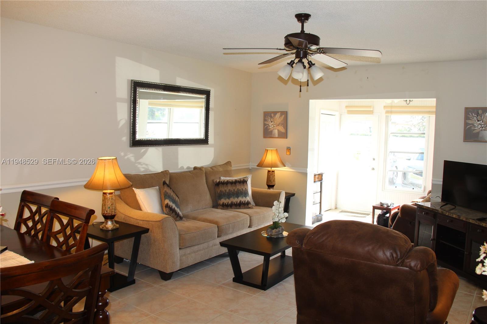 5620 Southwest 3rd Place, Unit 114 Margate, FL 33068 - Photo 27 of 29 a living room with furniture a chandelier and a window
