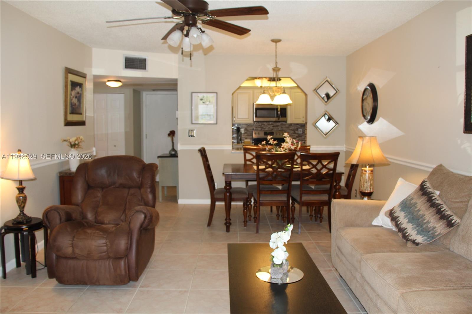 5620 Southwest 3rd Place, Unit 114 Margate, FL 33068 - Photo 28 of 29 a living room with furniture chandelier and a mirror