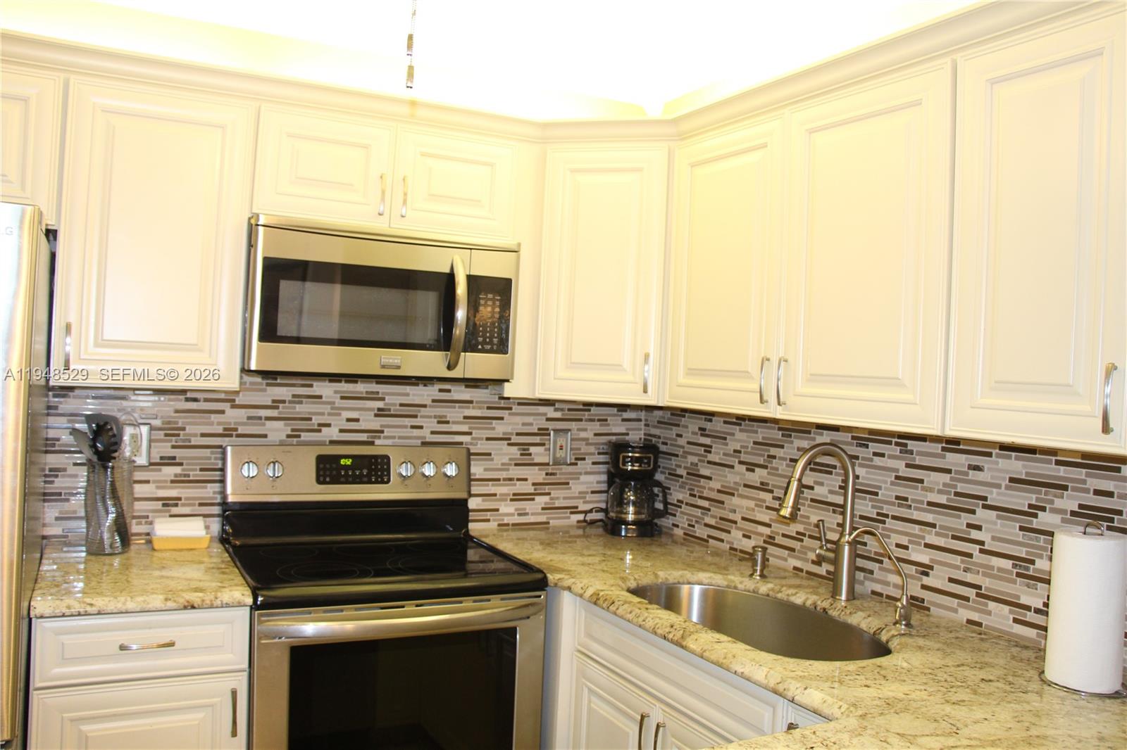 5620 Southwest 3rd Place, Unit 114 Margate, FL 33068 - Photo 4 of 29 a kitchen with stainless steel appliances a stove sink microwave and cabinets
