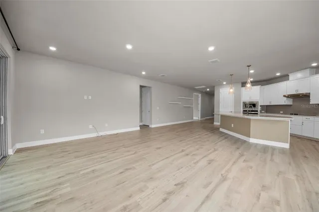 a view of kitchen with kitchen island granite countertop a sink and cabinets
