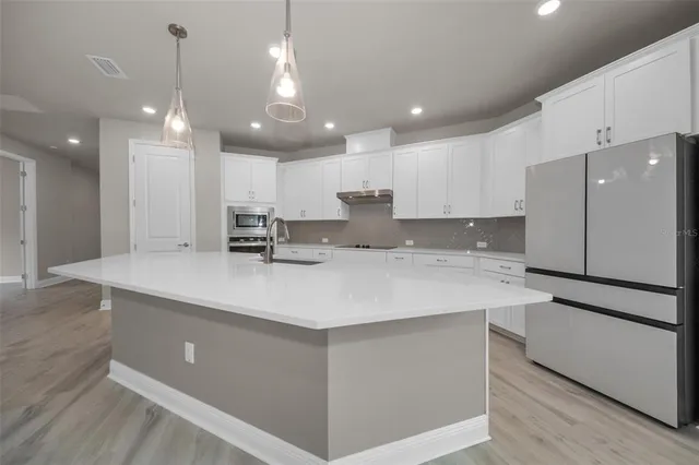 a kitchen with kitchen island a sink stainless steel appliances and cabinets