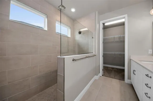 a bathroom with a glass shower door and a sink
