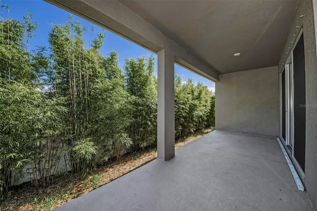 a view of a room with a large window and plants