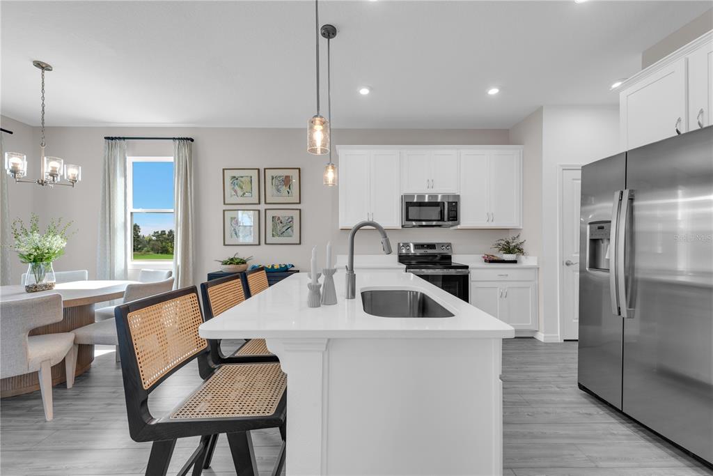 643 Rockaway Lane Cocoa, FL 32927 - Photo 6 of 34 a kitchen with a table chairs refrigerator and microwave