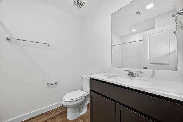a bathroom with a sink vanity mirror and toilet