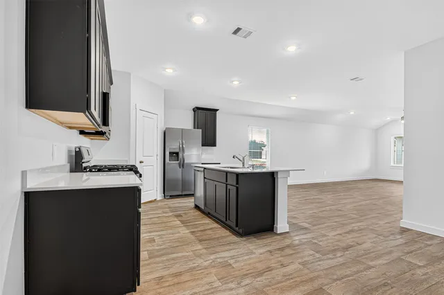 a kitchen with stainless steel appliances granite countertop a sink stove and refrigerator