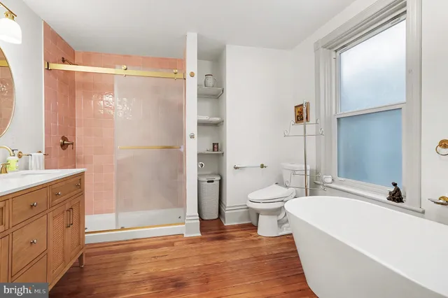 a bathroom with a granite countertop bathtub shower sink vanity and toilet