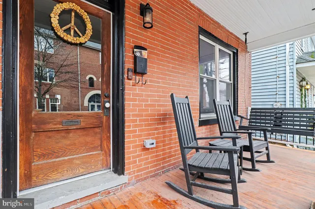 a view of a brick house with table chair and wooden floor