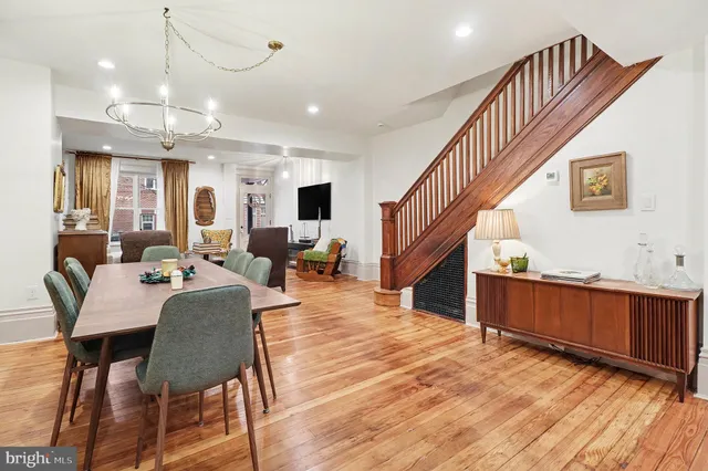 a living room with furniture kitchen view and a wooden floor