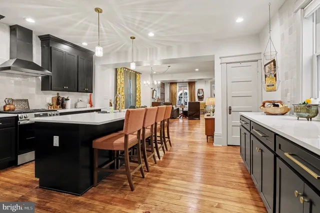 a kitchen with stainless steel appliances kitchen island granite countertop a table chairs sink and cabinets