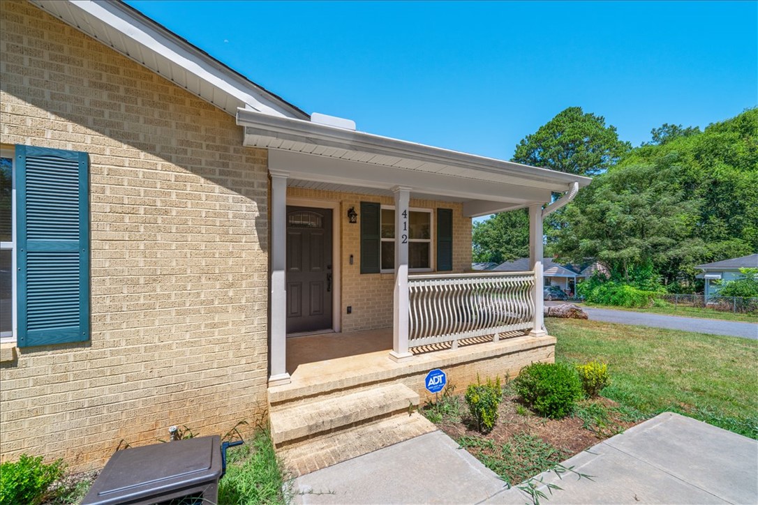 412 Sanders Street Anderson, SC 29624 - Photo 4 of 30 A welcoming front porch with sturdy columns and decorative railings offers inviting curb appeal.