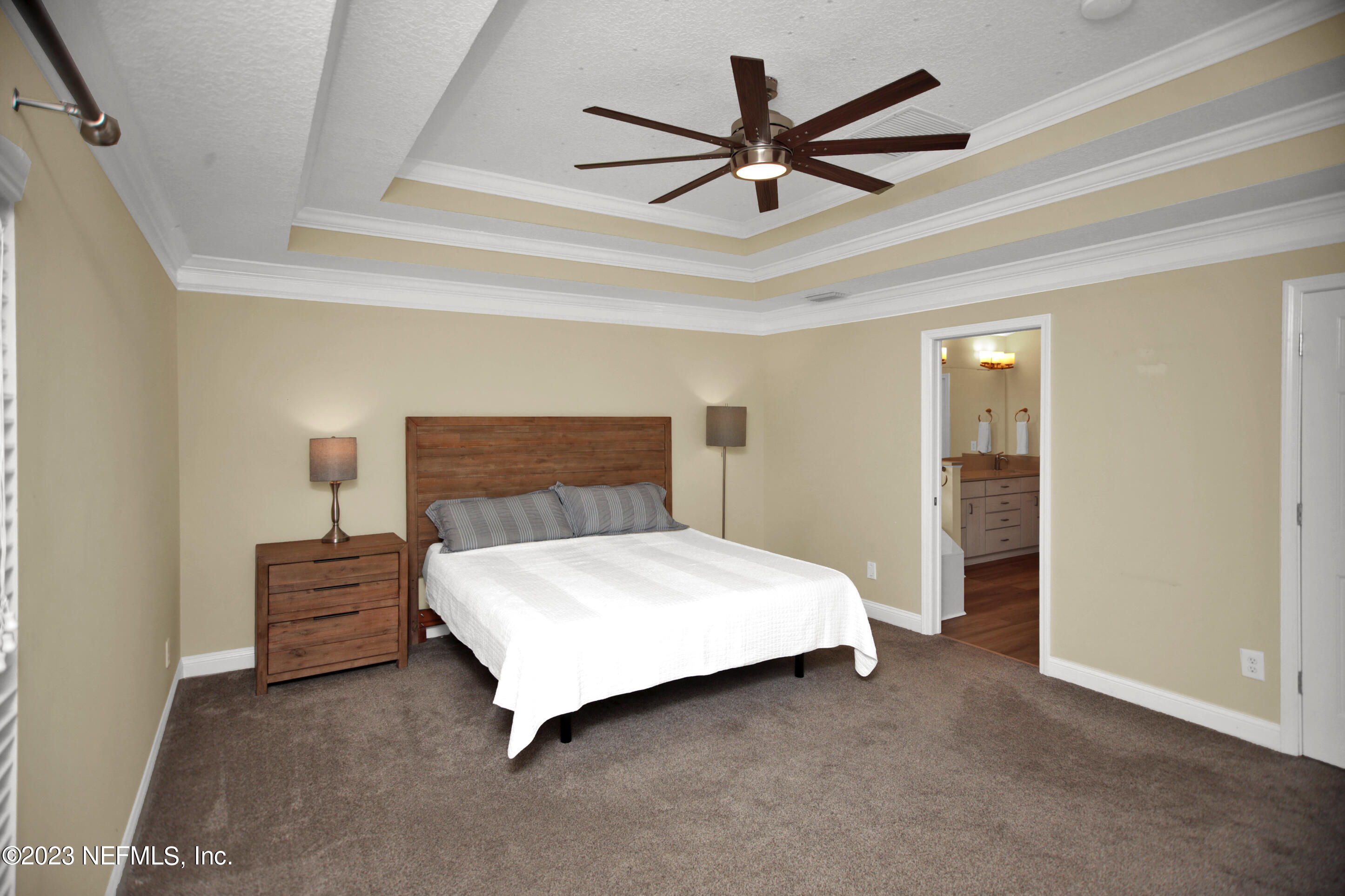 944 Oxford Drive St. Augustine, FL 32084 - Photo 19 of 58 a bedroom with a bed and a chandelier
