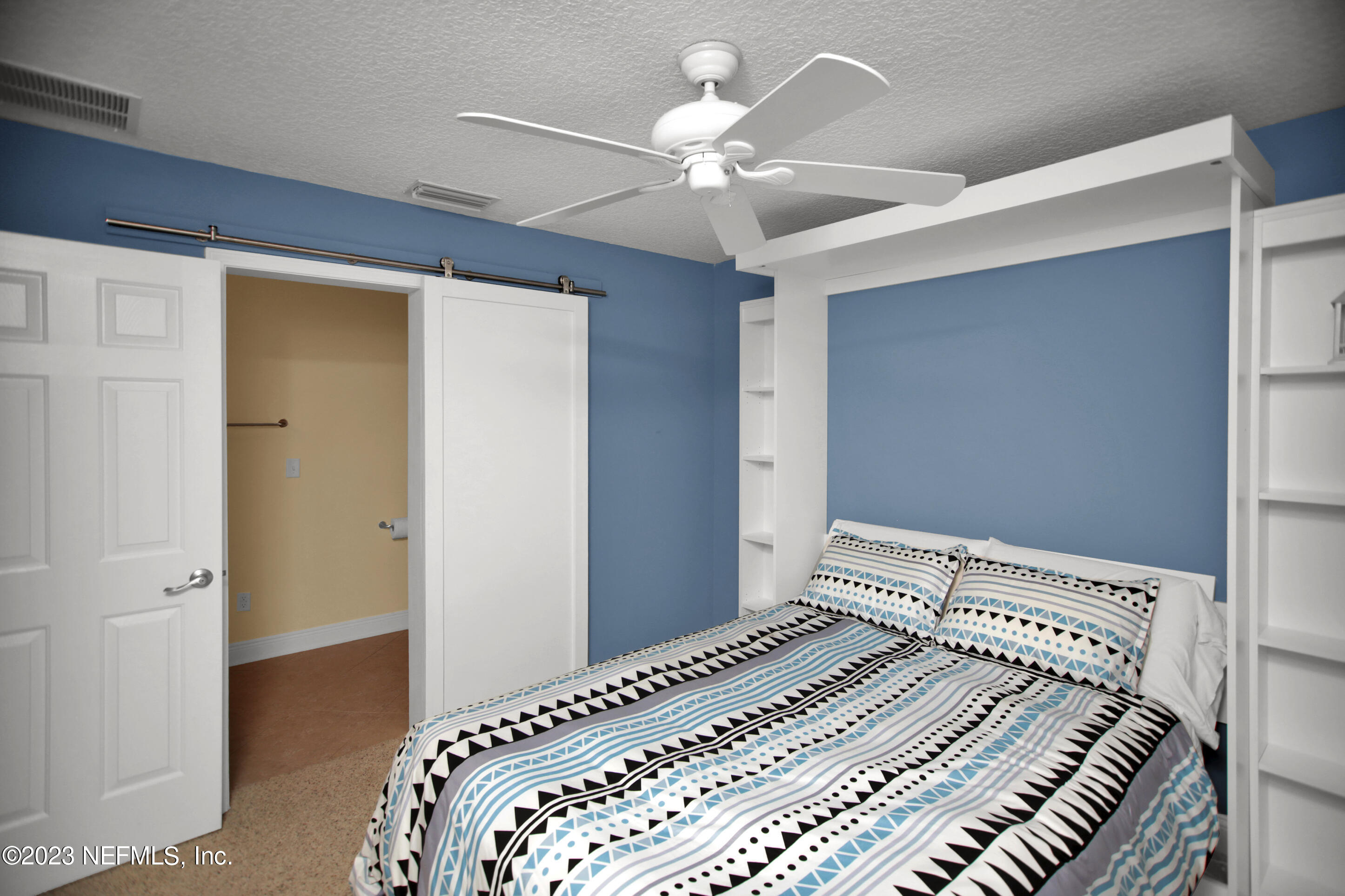 944 Oxford Drive St. Augustine, FL 32084 - Photo 28 of 58 a bedroom with a bed and a chandelier