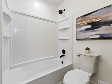 a white toilet sitting next to a bath tub and shower