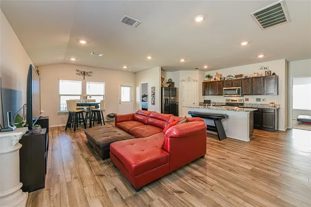 a living room kitchen with furniture and a wooden floor