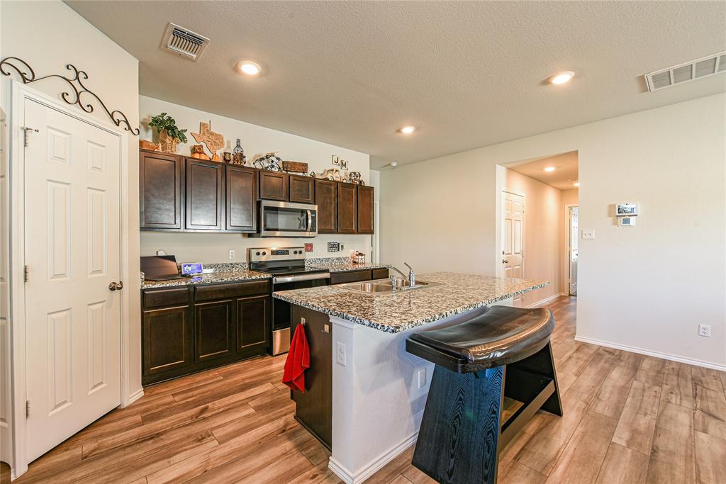 348 Jacquard Court Troy, TX 76579 - Photo 3 of 19 a kitchen with stainless steel appliances granite countertop a sink stove and refrigerator