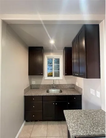 a bathroom with a granite countertop double vanity sink and a mirror