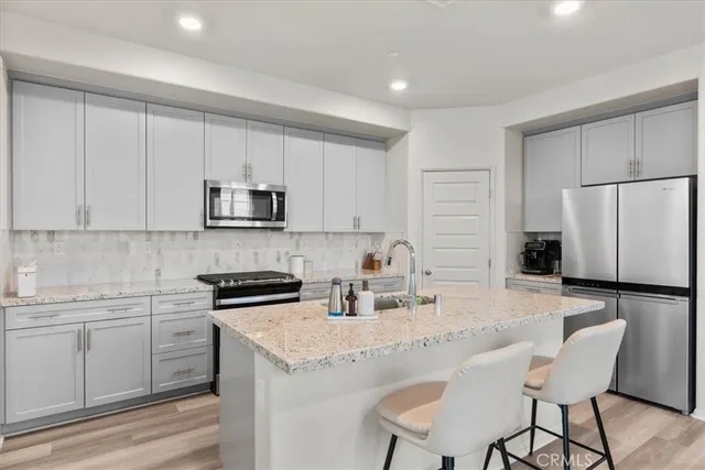 a kitchen with a sink a stove a refrigerator and white cabinets