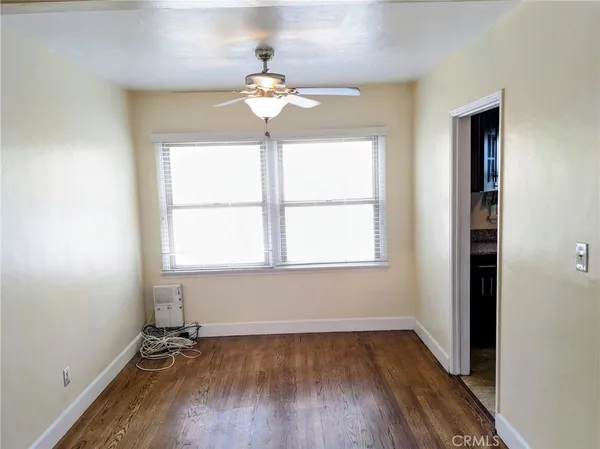 an empty room with a window and wooden floor