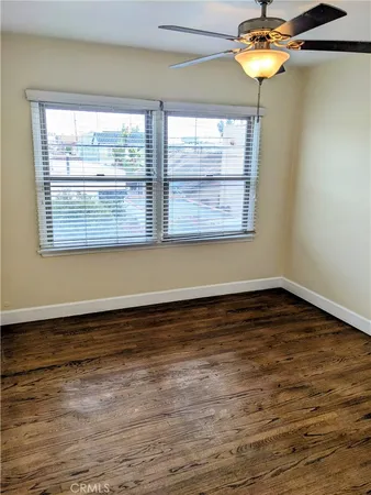a view of a room with wooden floor and a window