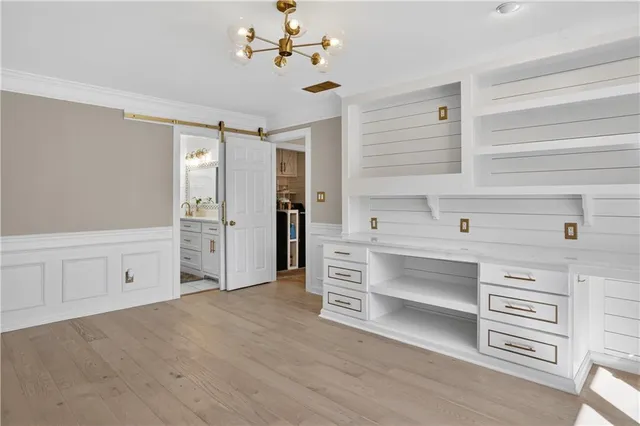 a view of a bedroom with cabinet cabinet a ceiling fan and windows