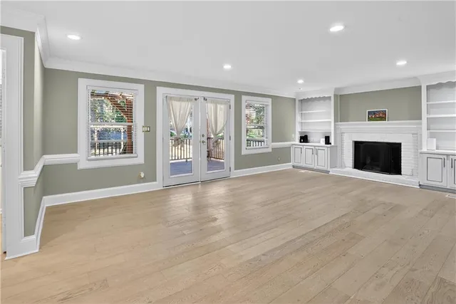a view of an empty room with a window and fireplace