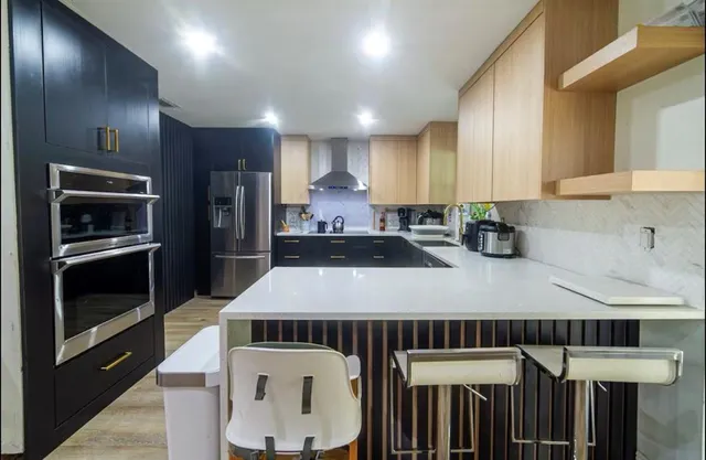 a kitchen with kitchen island granite countertop a stove a sink and a refrigerator