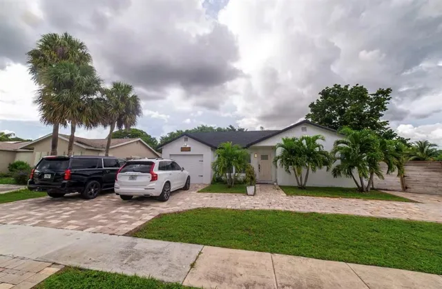 a couple of cars parked in front of a house