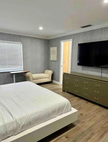 a bedroom with a bed and flat screen tv