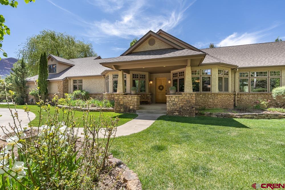 970 Red Rock Road Durango, CO 81301 - Photo 1 of 35 a front view of a house with a yard table and chairs