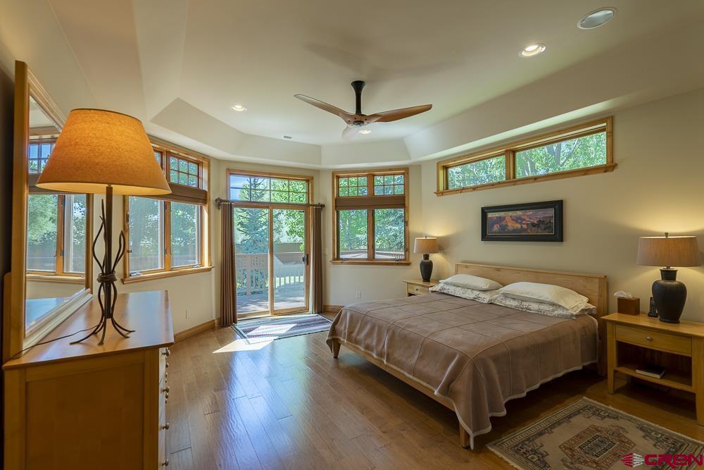 970 Red Rock Road Durango, CO 81301 - Photo 11 of 35 a bedroom with a bed and a lamp on dresser next to a window