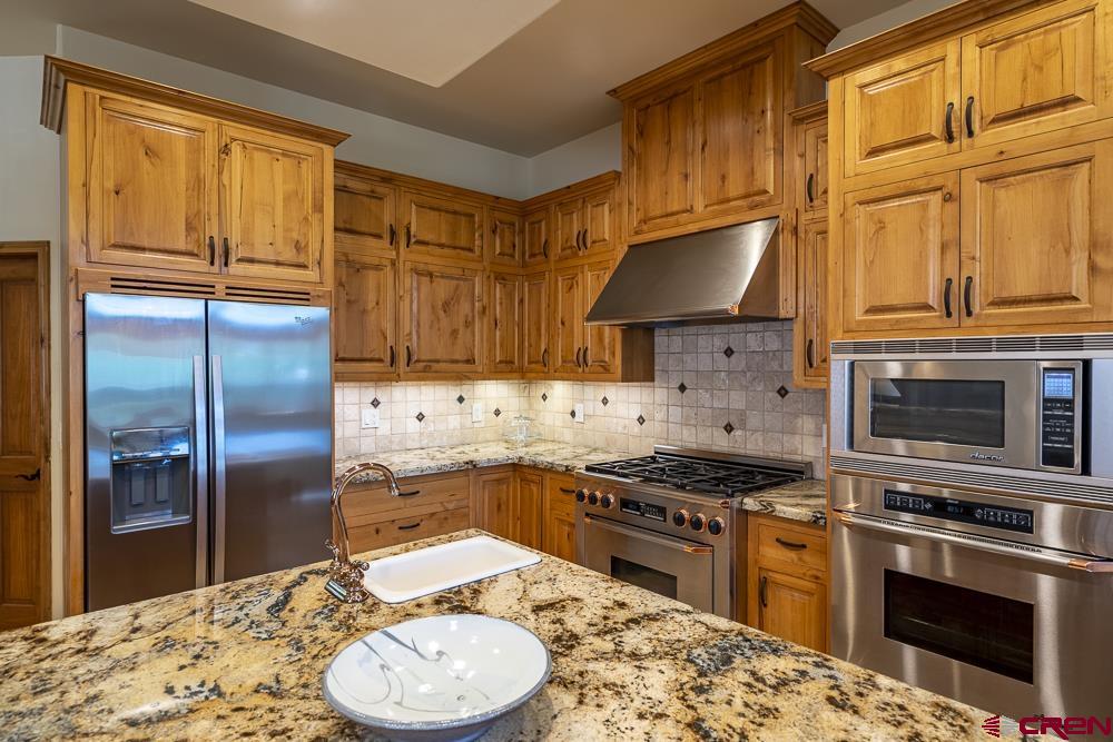 970 Red Rock Road Durango, CO 81301 - Photo 18 of 35 a kitchen with stainless steel appliances granite countertop a stove a sink and a refrigerator